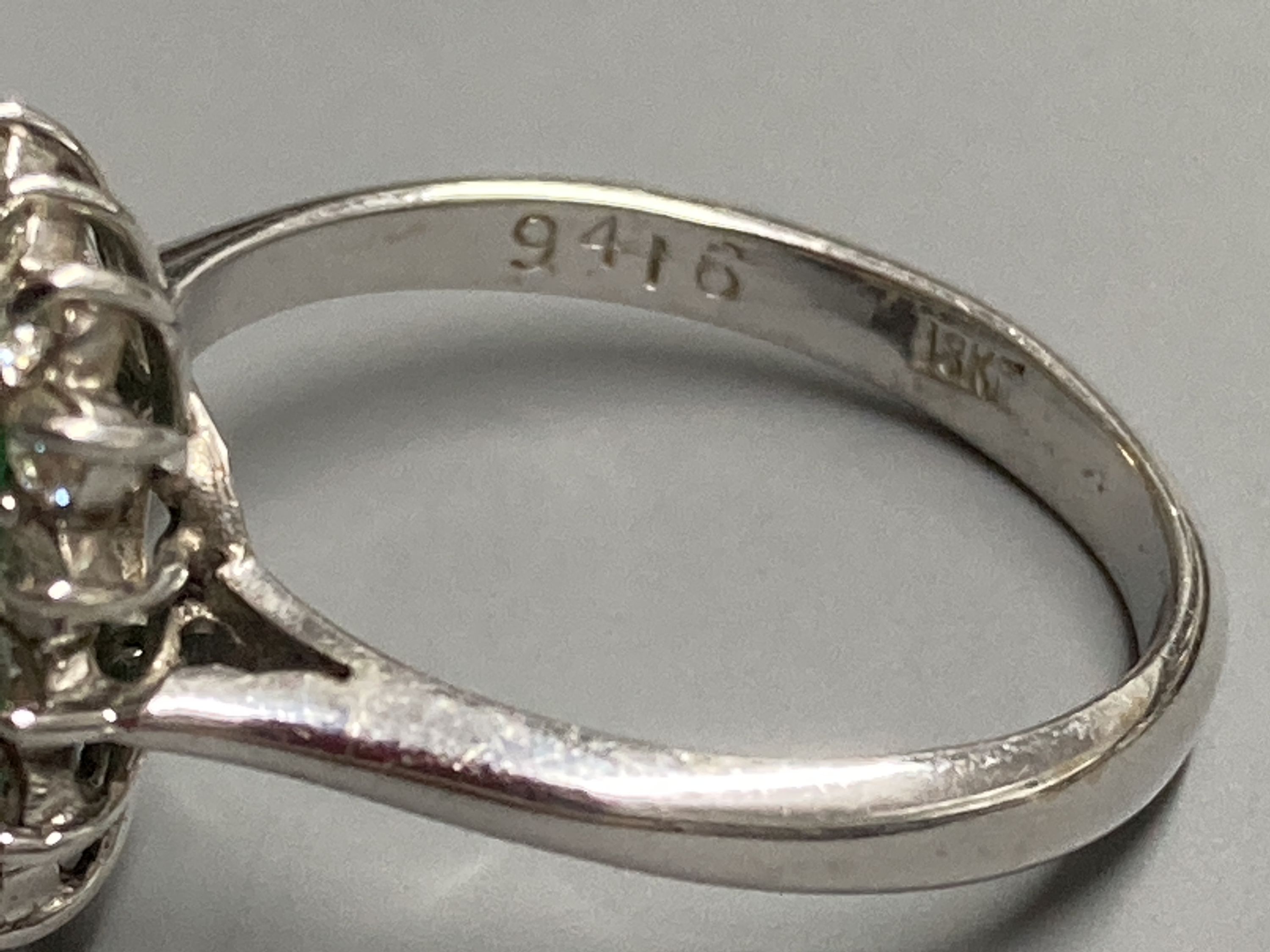 A modern 18ct white gold, emerald and diamond set rectangular cluster ring, size K, gross 3.4 grams.